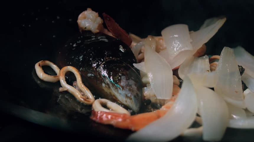 The food is cooking in the wok with oil