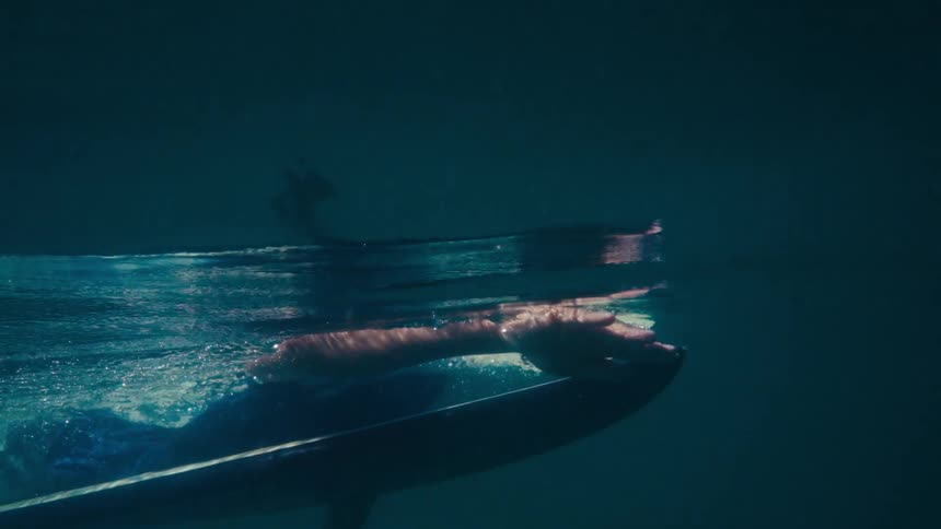 A person swims in the ocean at midday