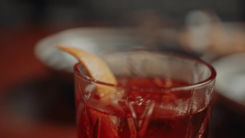 A mixed drink has an orange wedge in it