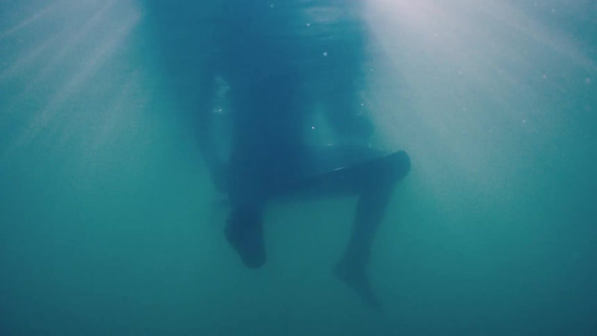 View from inside the sea and the legs of a person swimming