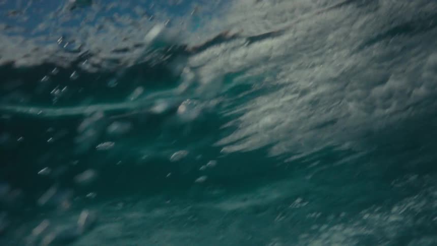 A man surfs on a wave in the ocean during daylight
