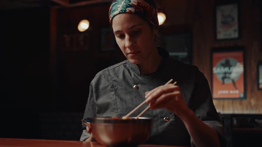 A chef carefully plating food in a restaurant kitchen