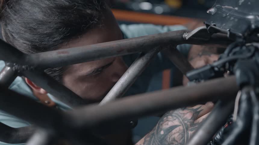 A man works on a vehicle with his hands