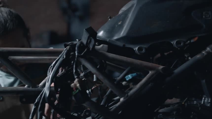 A mechanic works on a motorcycle in the workshop