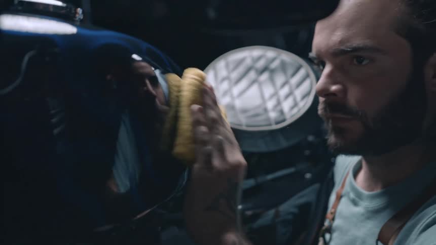 Man wiping the outside of a motorcycle engine