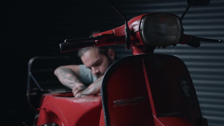 The man is carefully working on the vehicle engine