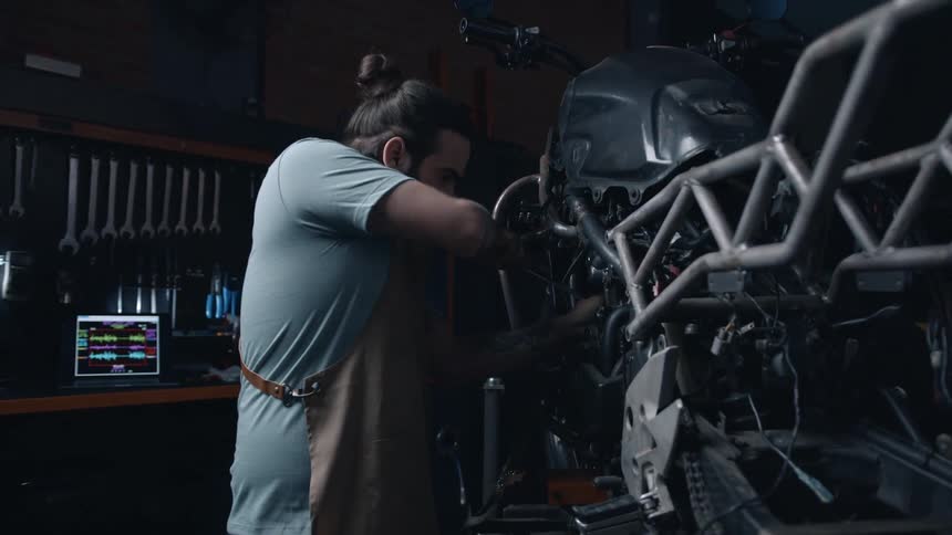 Mechanic working on a motorcycle in the garage