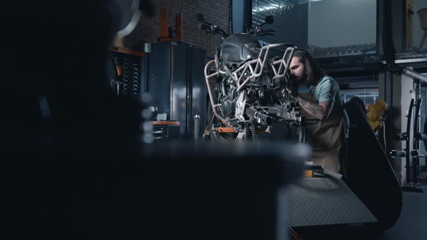 The mechanic is working on a motorcycle