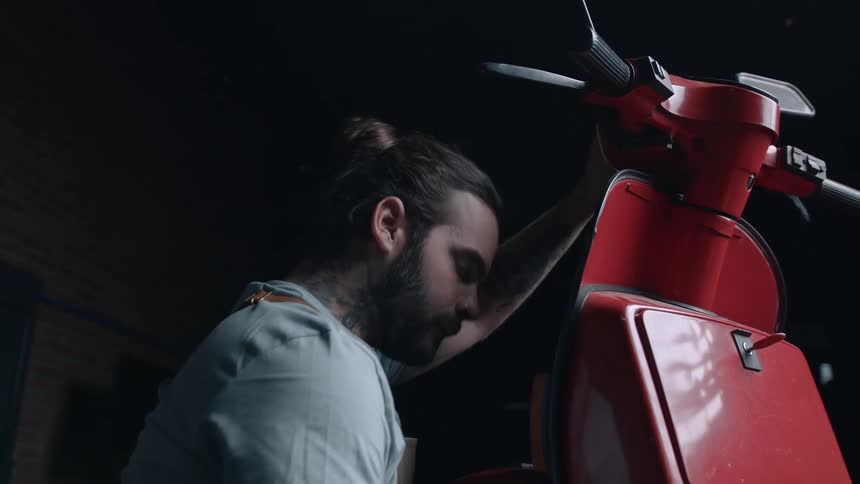 Mechanic working on a vintage red motorcycle