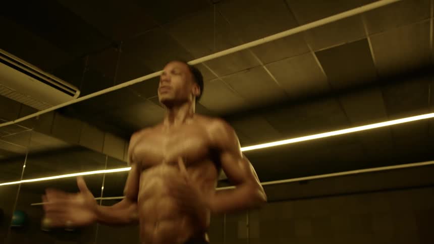 Strong fit male doing high knees workout in a gym