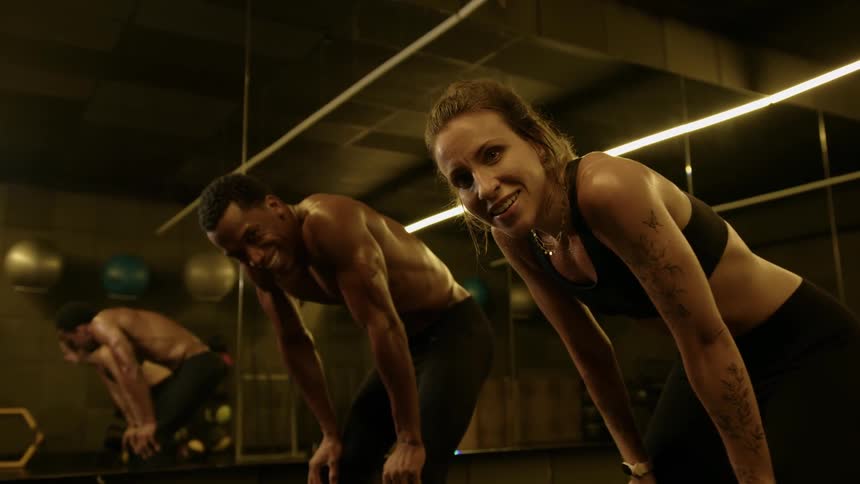Man and woman rest exhausted after intense workout in gym