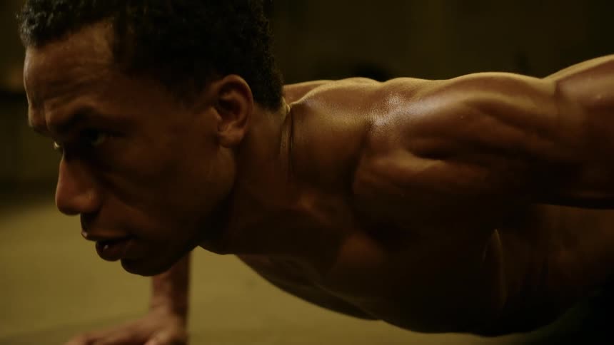 The man is doing push ups without a shirt on