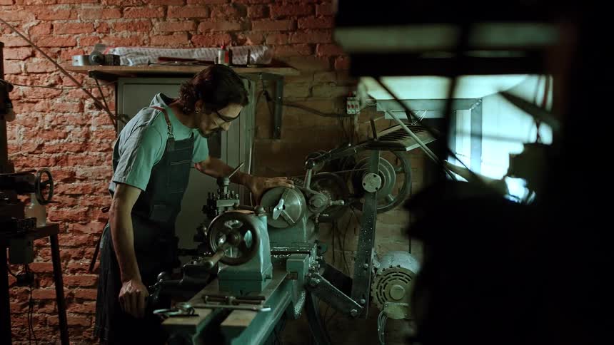 The man is working on machines in the shop