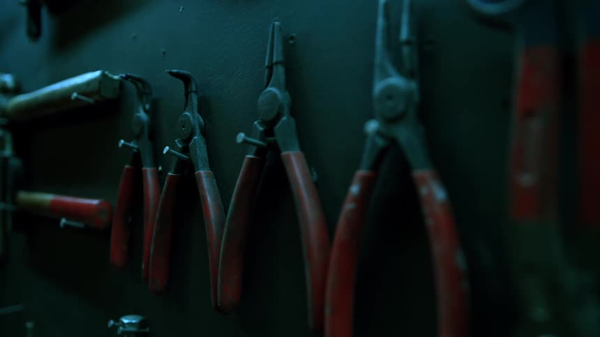 A hammer and other tools are placed inside a workstation