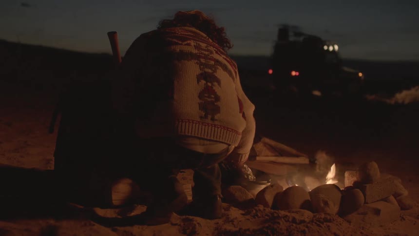 A fire burns outside at night