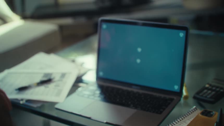 A man leans forward and types on his laptop
