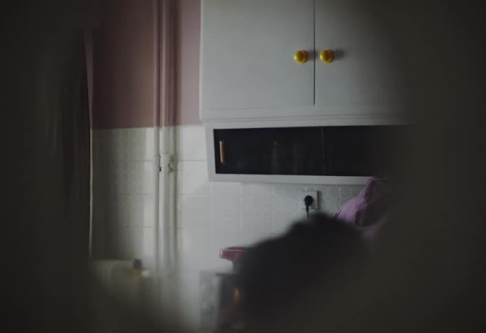 Mother and daughter in the kitchen seen through a small hole