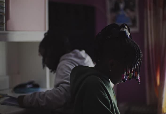Two girls are doing homework in the bedroom