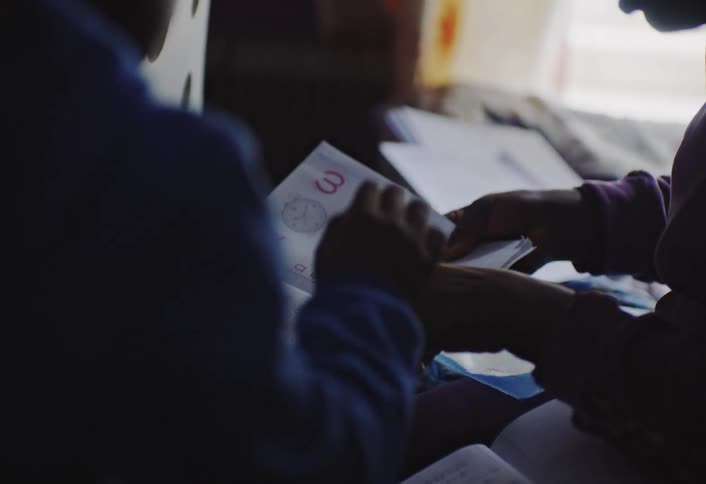 Two people are studying the symbols in a notebook