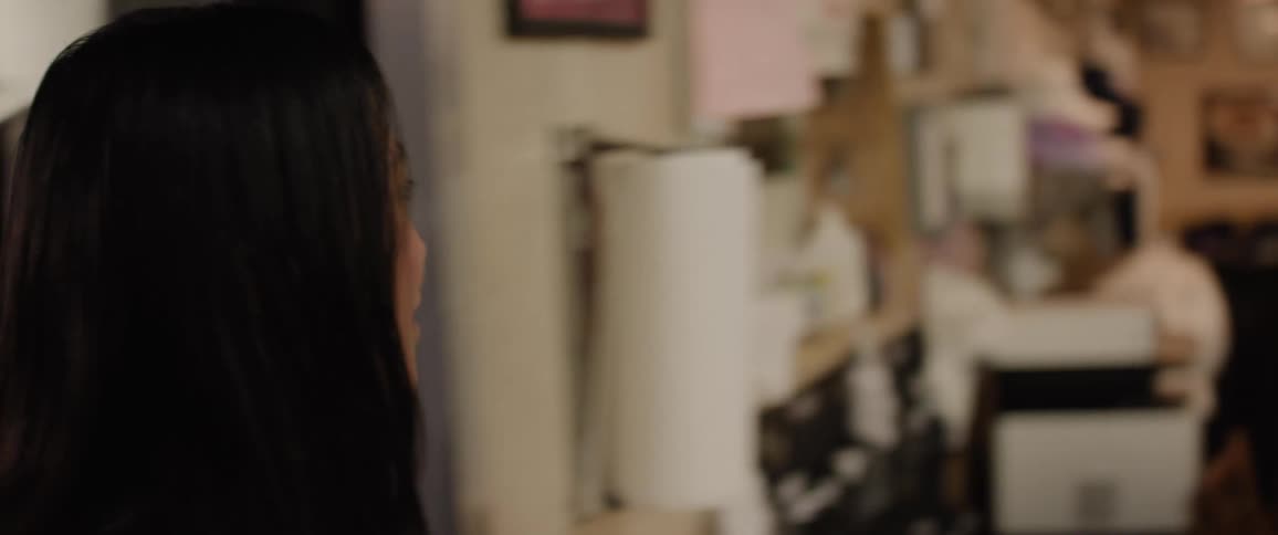 A woman walks into a restaurant filled with both workers and customers