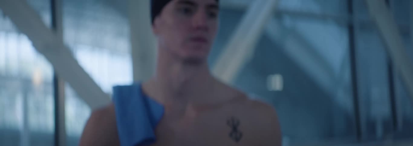 The swimmer walks by wearing a swim cap