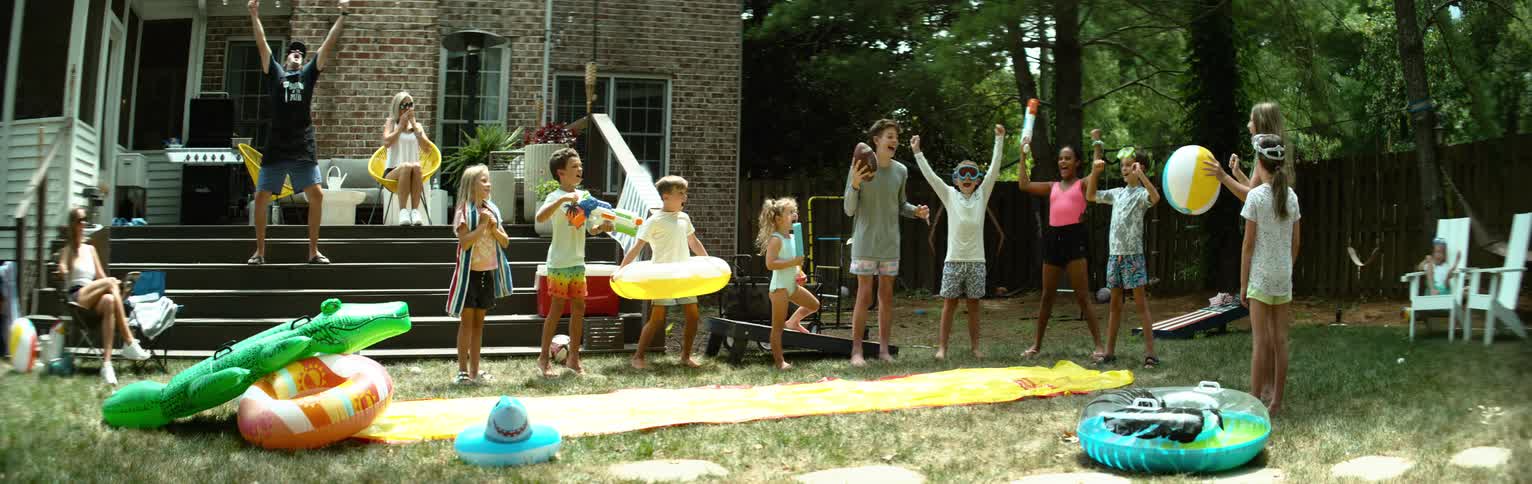 Group of children in a backyard cheering happily and playing