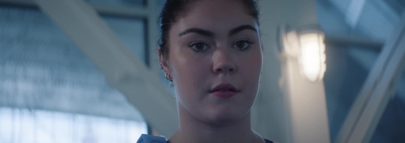 Portrait of a woman with her hair tied up in an indoor space