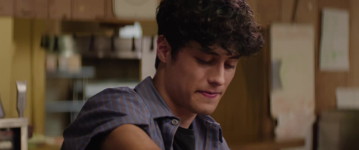 Young man blinking his eyes while pouring coffee into a mug