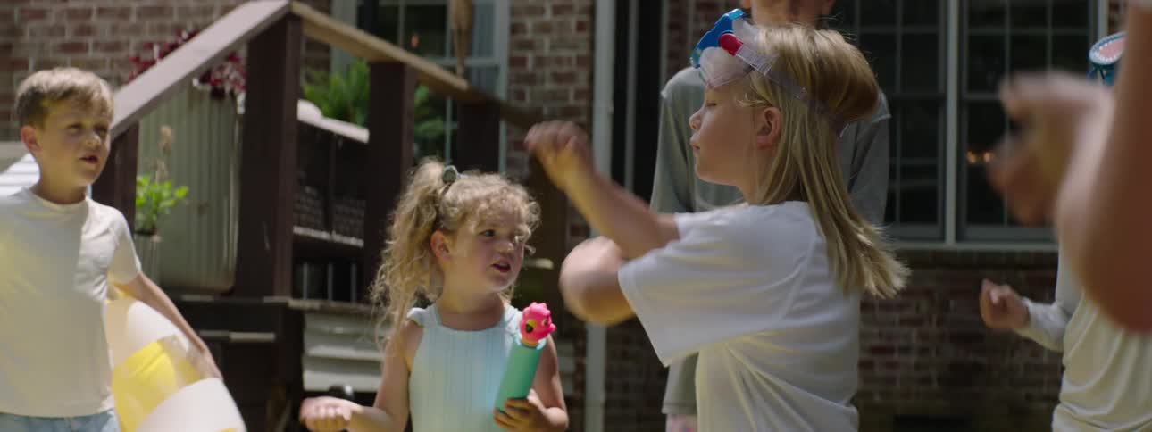 Children with various toys playing in a backyard