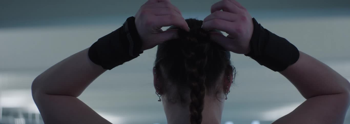 View of a woman from behind adjusting her hair braids