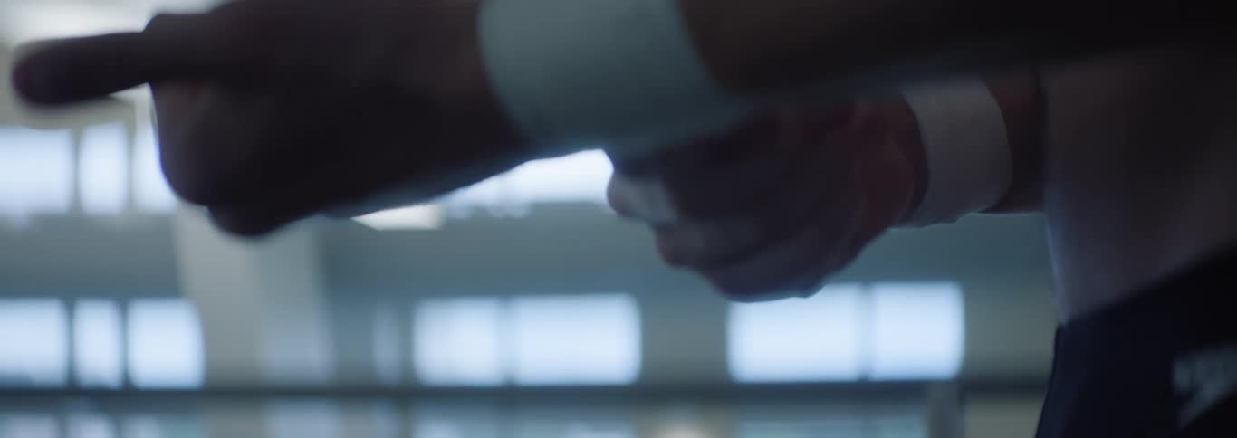 A male swimmer prepare by wrapping tape around his wrists