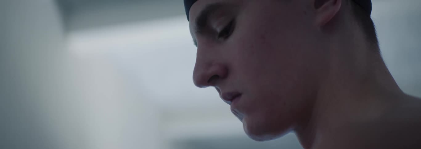 The swimmer looks up and blinks
