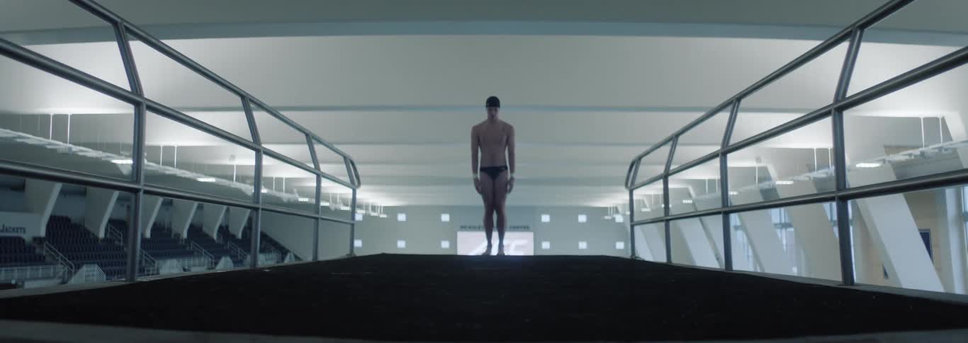Person in swim trunks and a swimming cap in an indoor environment