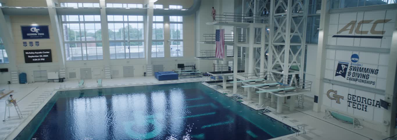A diver plunges into a large indoor pool