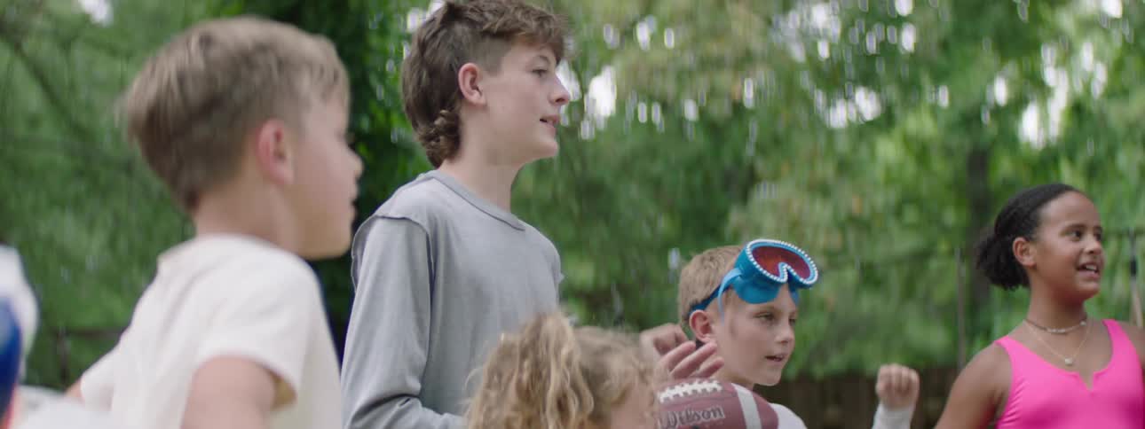 Group of kids in a backyard cheering together