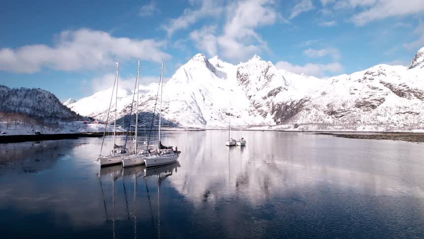 The sailboats are anchored in the lake water