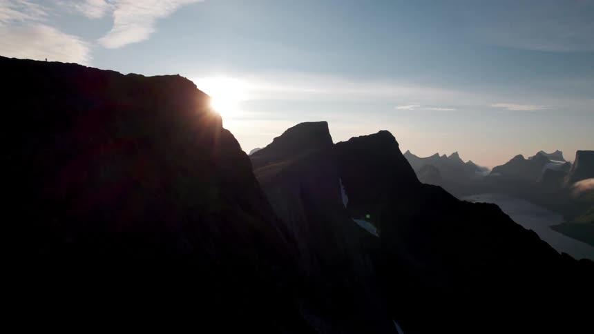 A mountain site with a rugged peak is seen at sunrise