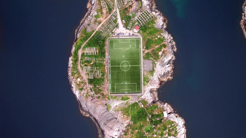 An aerial view of a soccer stadium on an island surrounded by ocean water