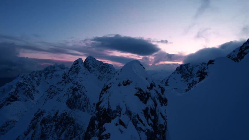 Landscape of snowy mountains in a violet dawn sky