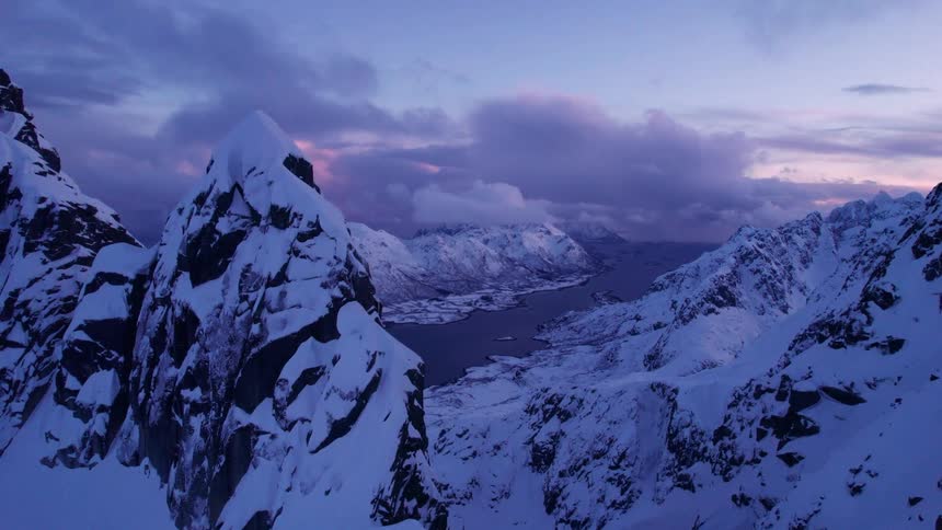 The sun is rising on the snow covered mountains