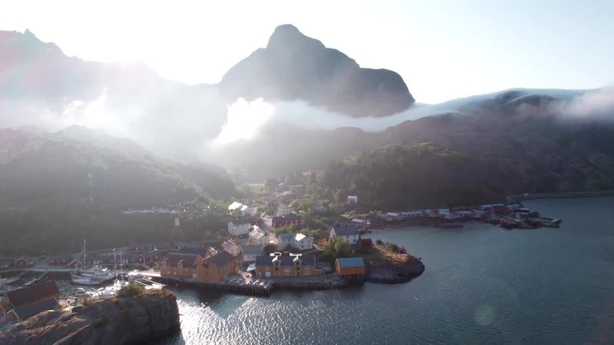 Aerial panorama of a rural seaside setting with mountains in the background