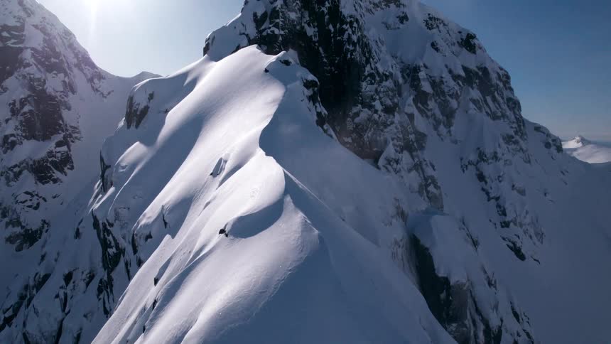 The bright sun shines on the snow covered mountain