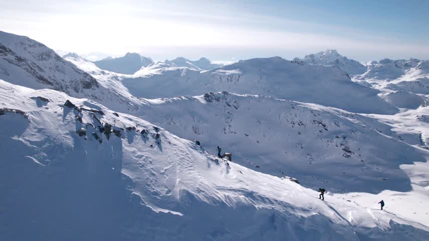 Group of people climbing a snow covered mountain
