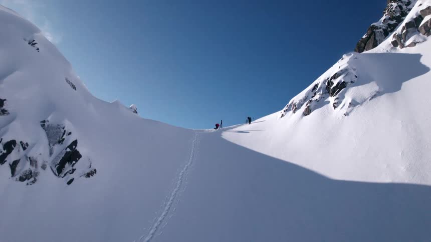 Hikers walking on a snowy mountain ridge