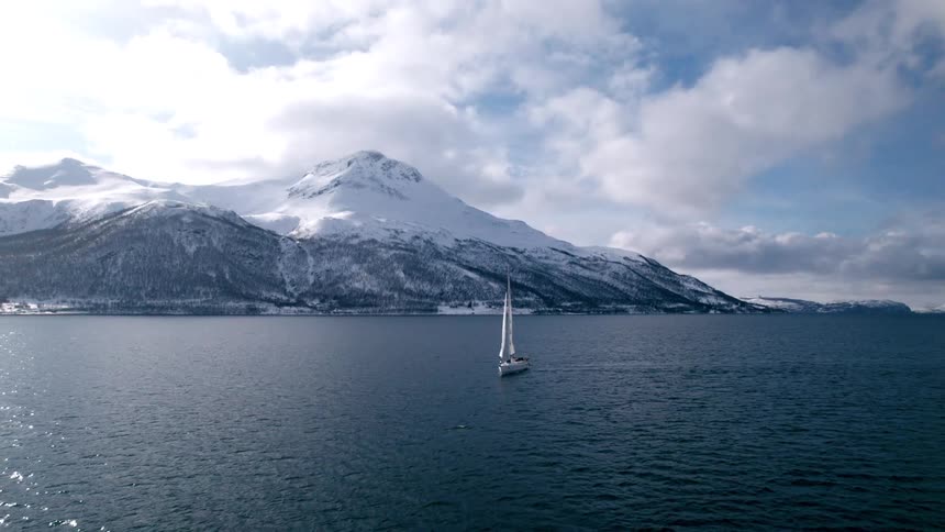 A sailboat on a lake near the mountains