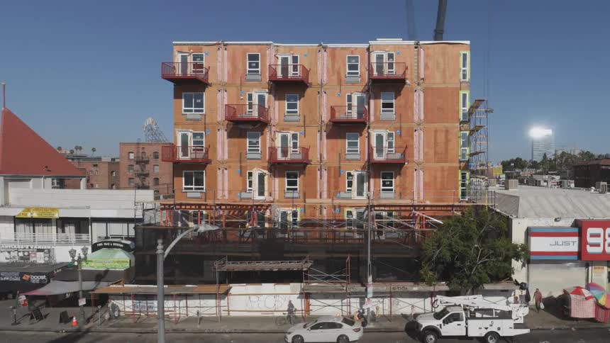 The video is a timelapse showing the construction of a multistory building from its foundation to near completion the construction begins with the skeletal structure and progresses with the addition of modular units external cladding and balconies
