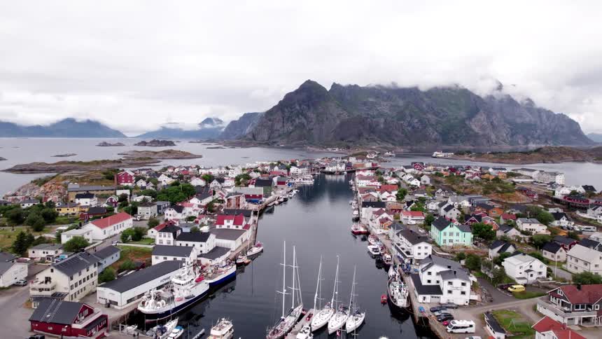 Urban city located by the sea with mountains in the background on a cloudy day