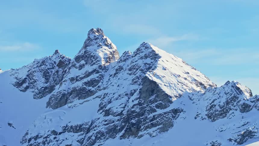 Half the snow covered mountain is covered in shade