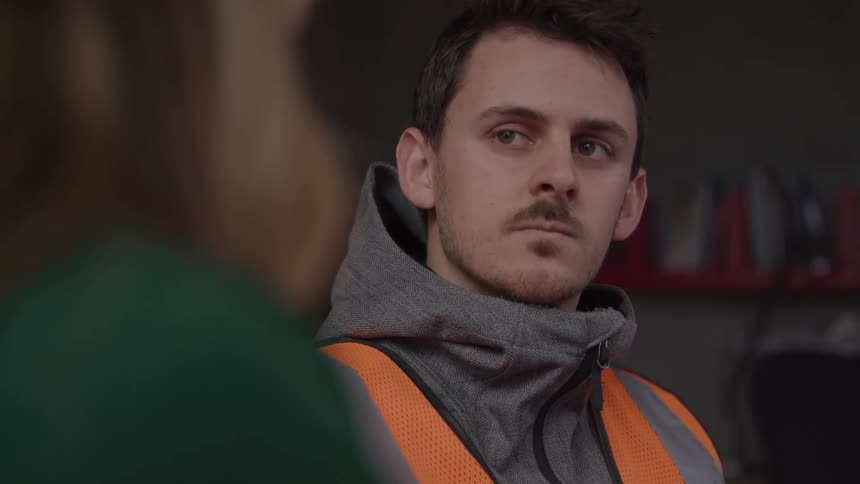A man subtly nod his head while listing to another person talking