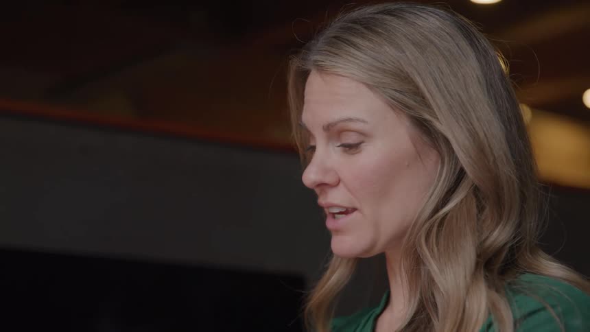 Woman with blond hair talking inside